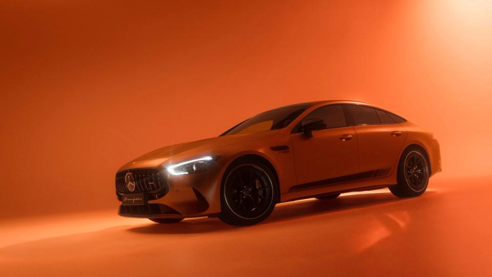 A Mercedes-AMG GT 4 door coupé bathed in orange light.