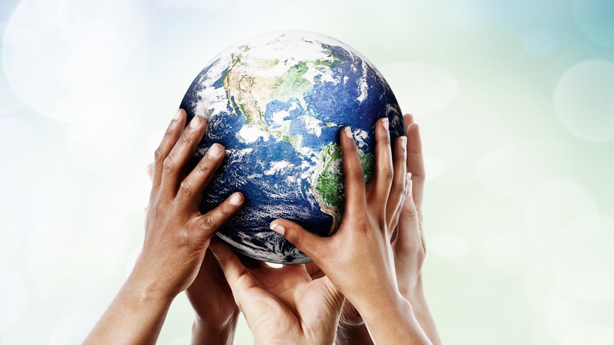 A globe carried by many hands.