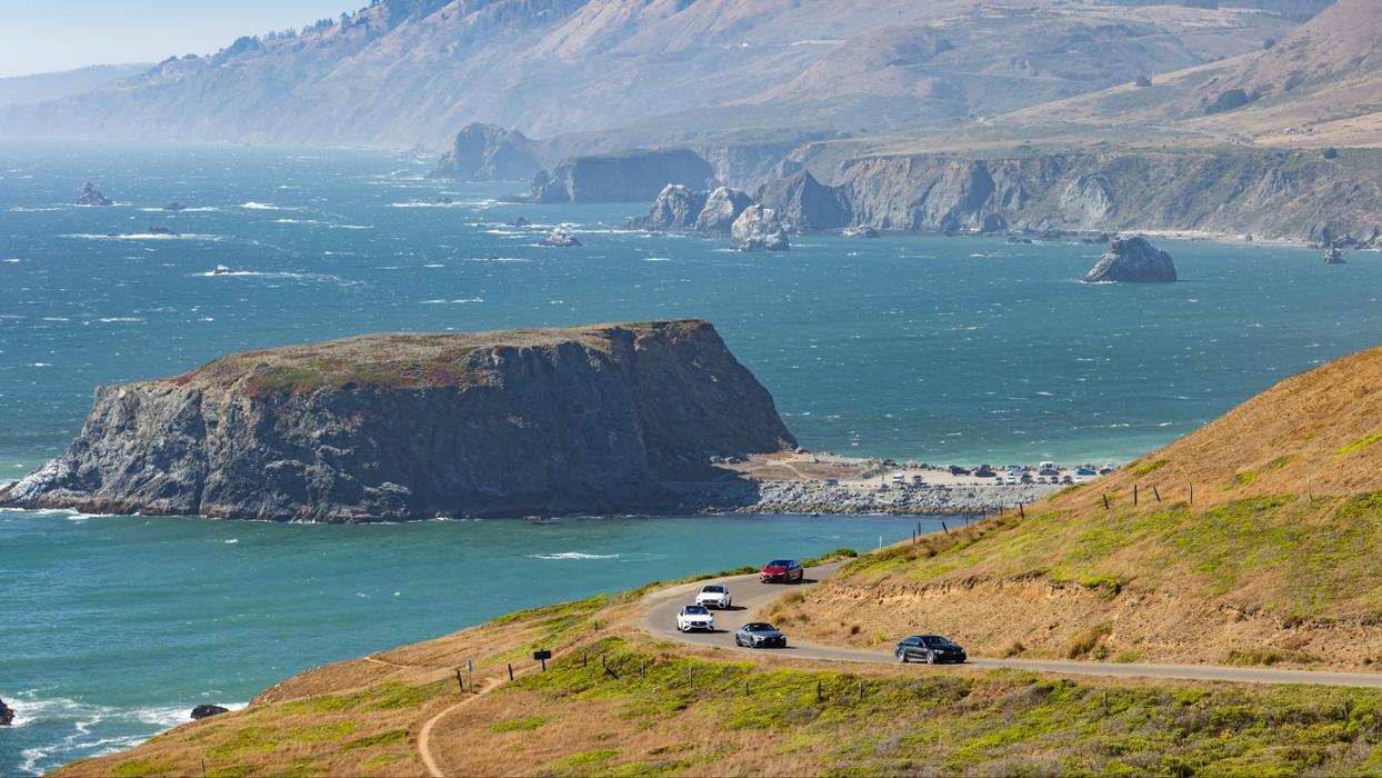 A rock island in the US with Mercedes-AMG vehicles in the foreground